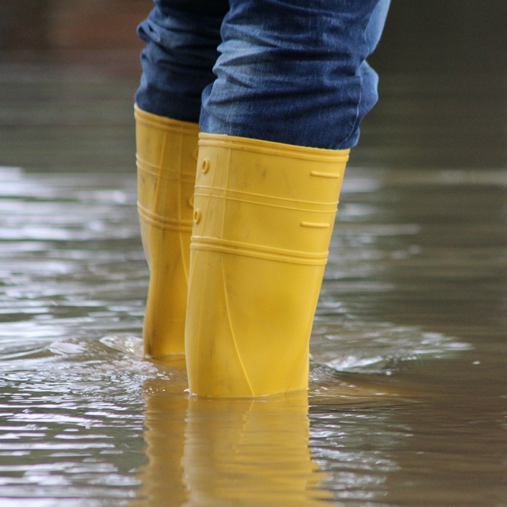 Met regenlaarzen in overstroming staan